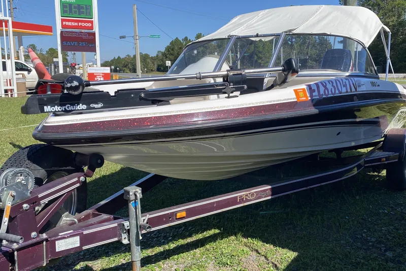 Slide: The Image of 2001 ProCraft 180 Combo boat on trailer, parked near a gas station. - 2