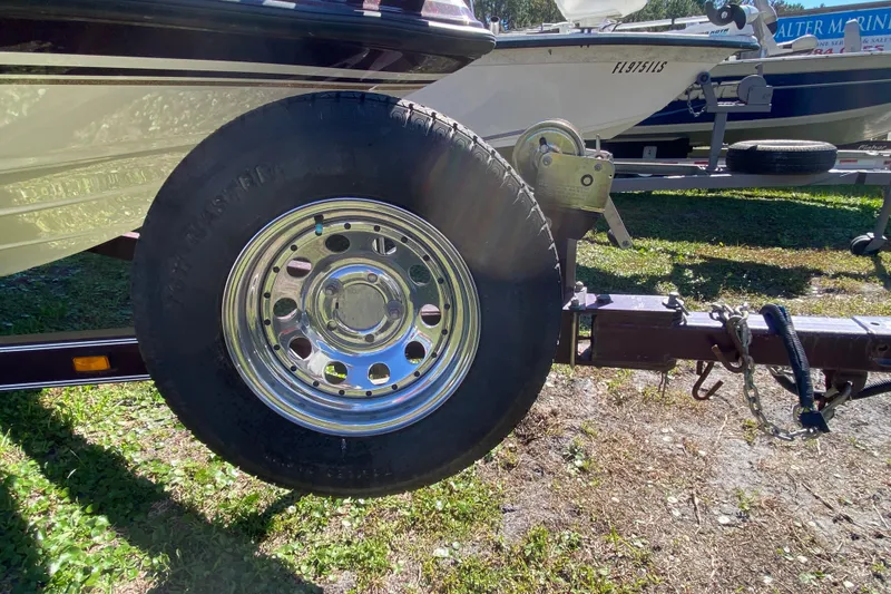 Slide: The Image of Trailer wheel of a 2001 ProCraft 180 Combo boat on grass. - 9