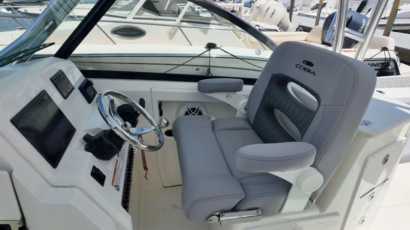 Slide: The Image of 2025 Cobia 240 Dual Console boat interior with gray seating and modern design. - 10