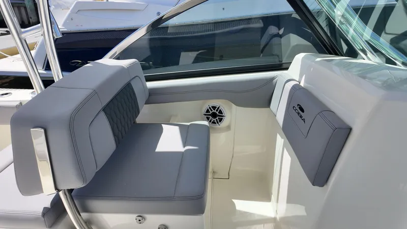 Slide: The Image of 2025 Cobia 240 Dual Console boat docked in a marina under a clear blue sky. - 12