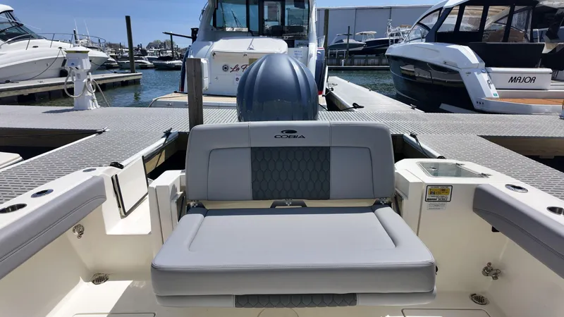 Slide: The Image of 2025 Cobia 240 Dual Console boat with Yamaha outboard engine, docked in sunlight. - 3