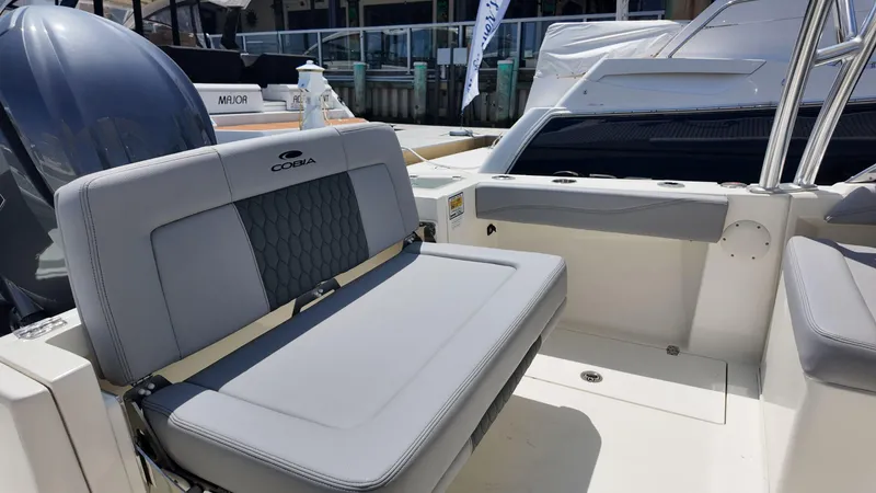 Slide: The Image of 2025 Cobia 240 Dual Console boat with open storage compartment and visible engine. - 4