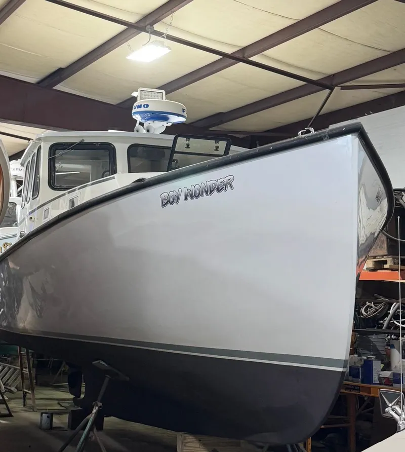 Slide: The Image of 1990 South Shore 30 Downeast boat named "Boy Wonder" in a storage facility. - 10