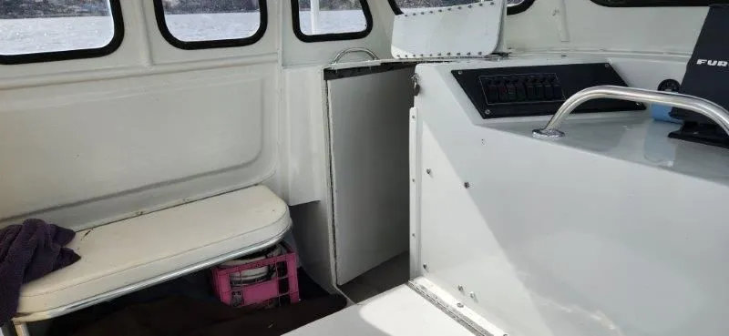 Slide: The Image of Interior of a 1990 South Shore 30 Downeast boat with seating and control panel. - 11