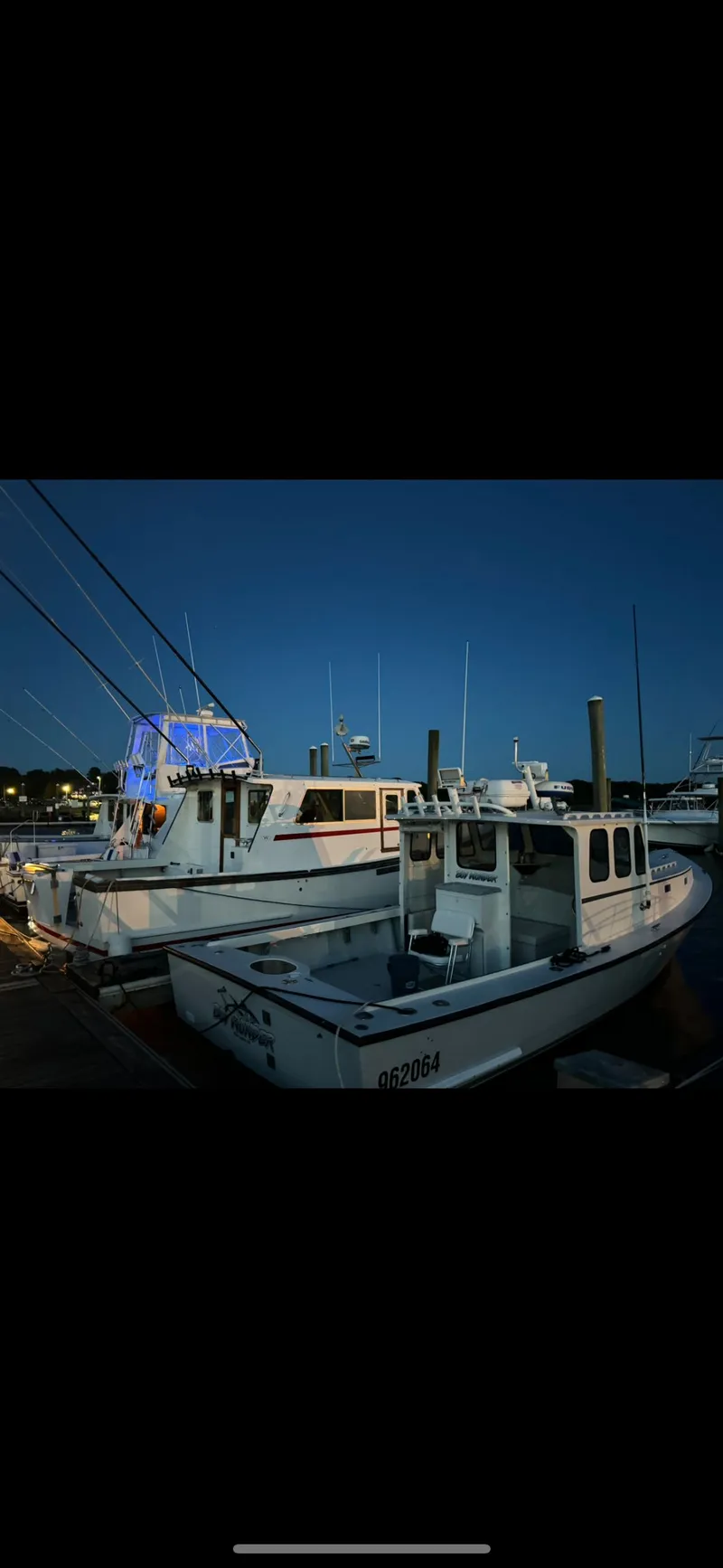 Slide: The Image of 1990 South Shore 30 Downeast boat docked at night, illuminated by soft lighting. - 23