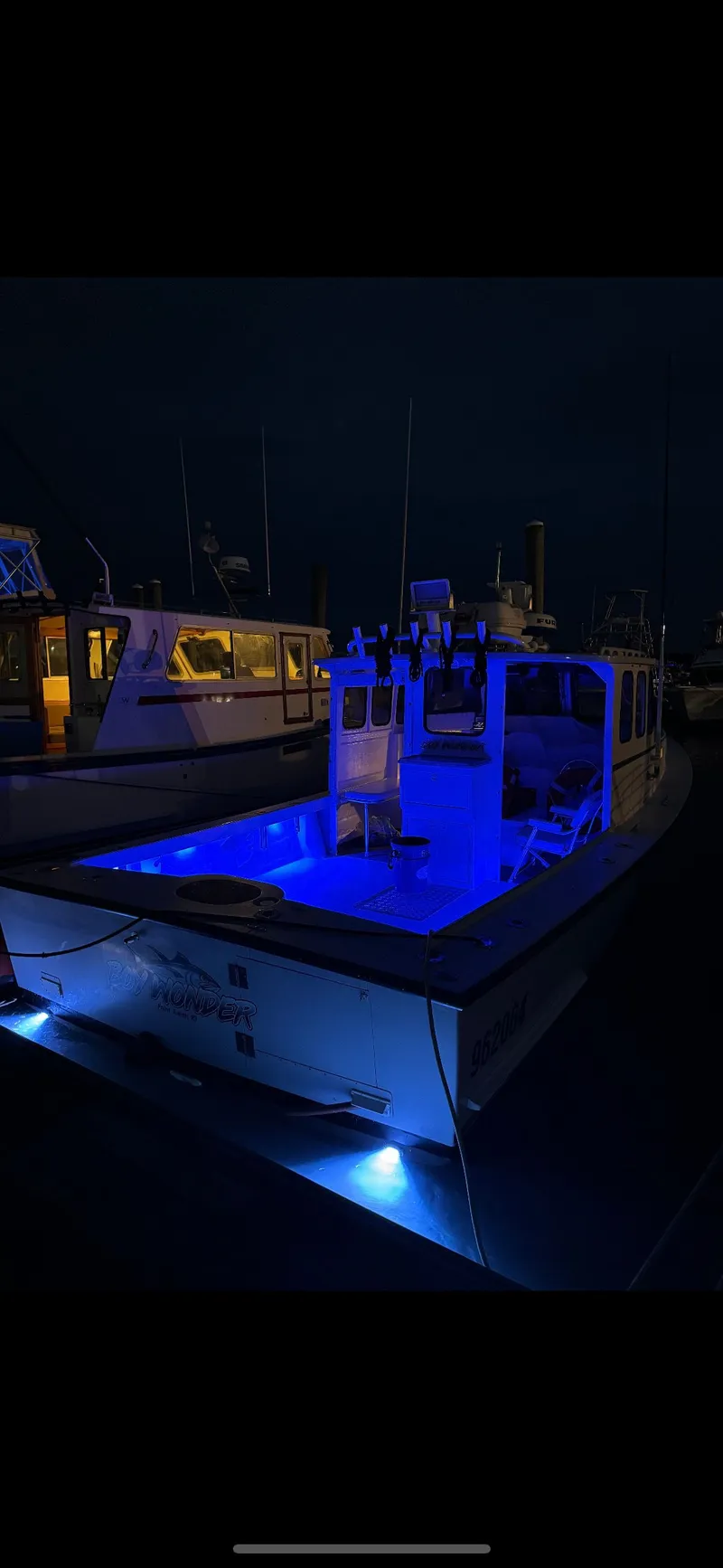 Slide: The Image of South Shore 30 Downeast boat, 1990 model, illuminated with blue lights at night. - 24