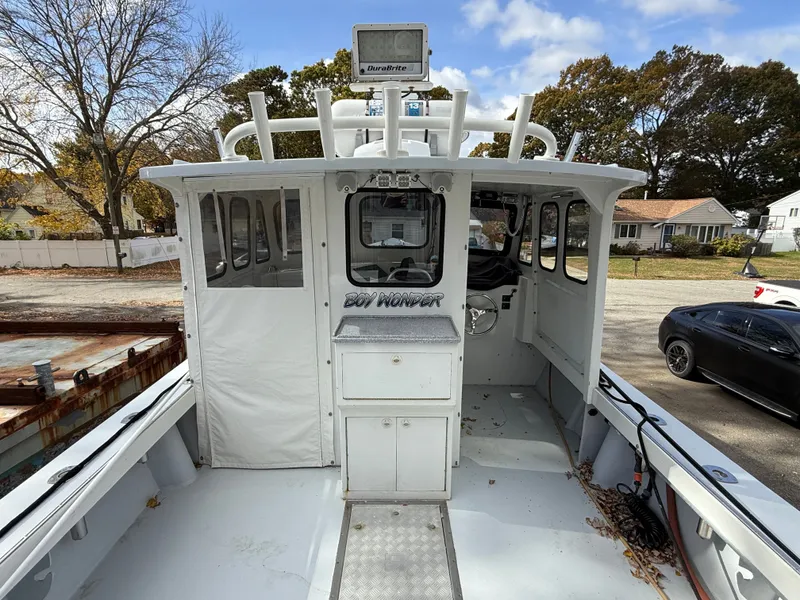 Slide: The Image of 1990 South Shore 30 Downeast boat with enclosed cabin, docked outdoors. - 4