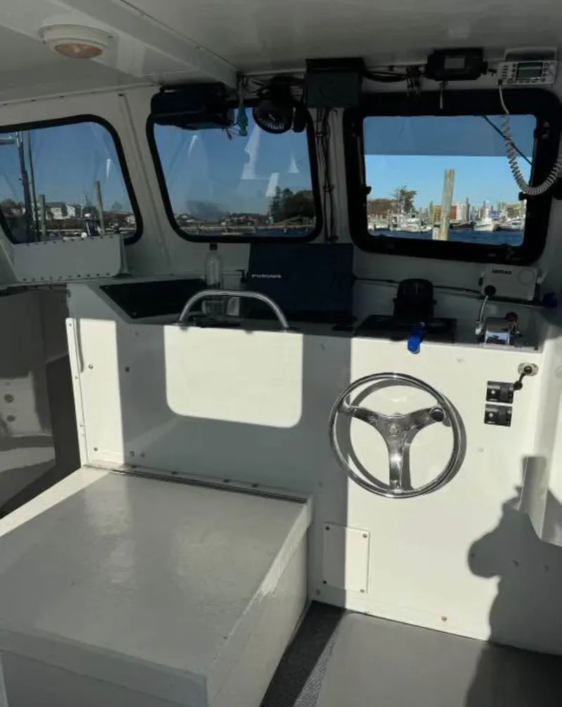 Slide: The Image of Interior of a 1990 South Shore 30 Downeast boat, featuring steering wheel and navigation equipment. - 5