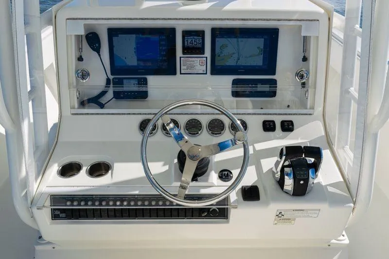 Slide: The Image of 2016 SeaVee 390Z boat dashboard with steering wheel, controls, and navigation screens. - 28
