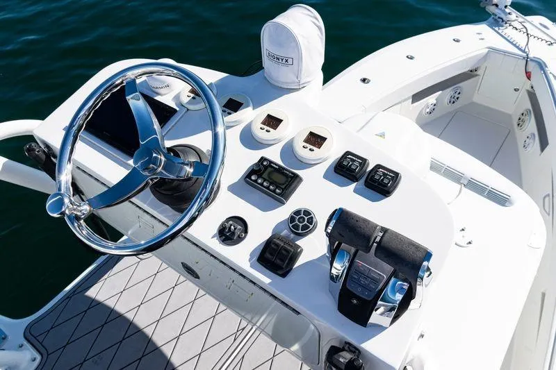 Slide: The Image of 2016 SeaVee 390Z boat helm with steering wheel and control panel on open water. - 45