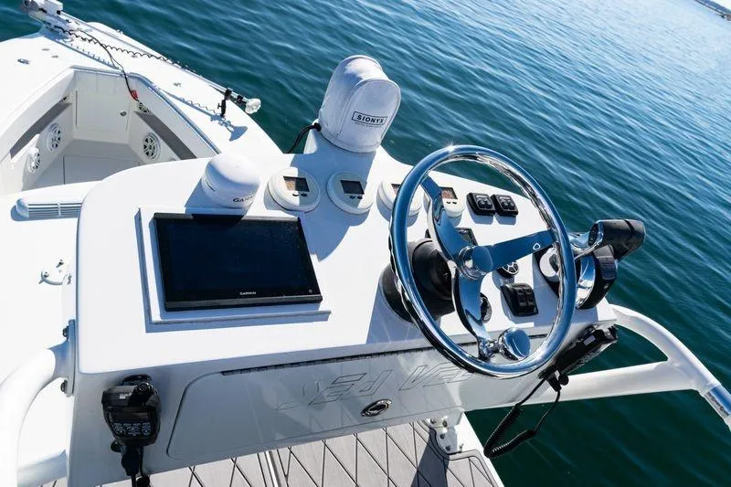 Slide: The Image of 2016 SeaVee 390Z boat dashboard with steering wheel and navigation equipment on calm water. - 49