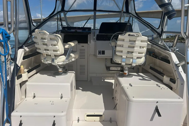Slide: The Image of 2004 Grady-White Marlin 300 boat cockpit with dual captain chairs and control panel. - 13