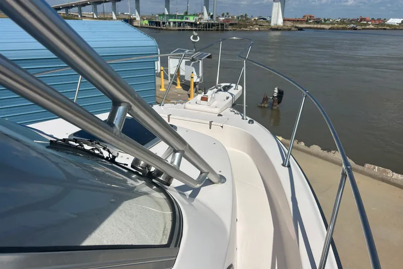 Slide: The Image of 2004 Grady-White Marlin 300 boat docked by a river with bridge in background. - 30