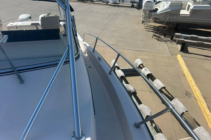 Slide: The Image of 2004 Grady-White Marlin 300 boat docked, showing bow rail and deck details. - 33