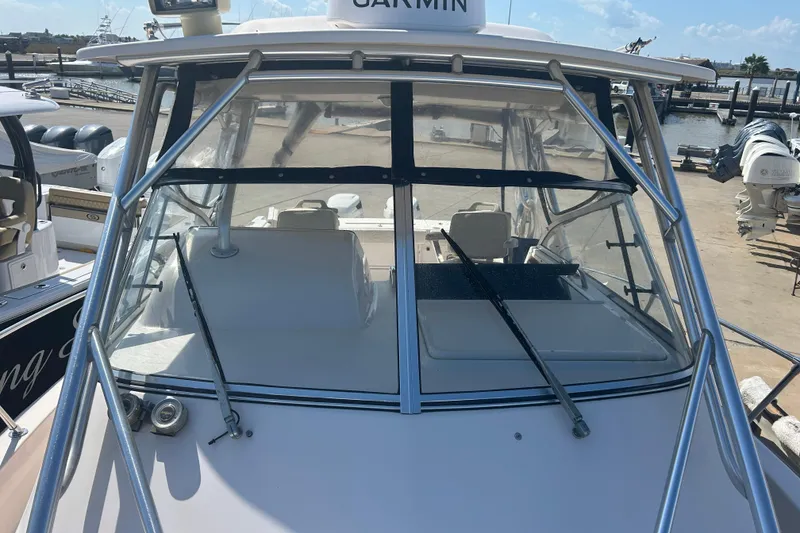 Slide: The Image of 2004 Grady-White Marlin 300 boat with windshield and Garmin equipment at a marina. - 34