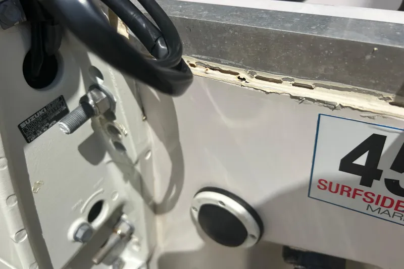 Slide: The Image of Close-up of a 2004 Grady-White Marlin 300 boat with visible Suzuki engine details. - 40