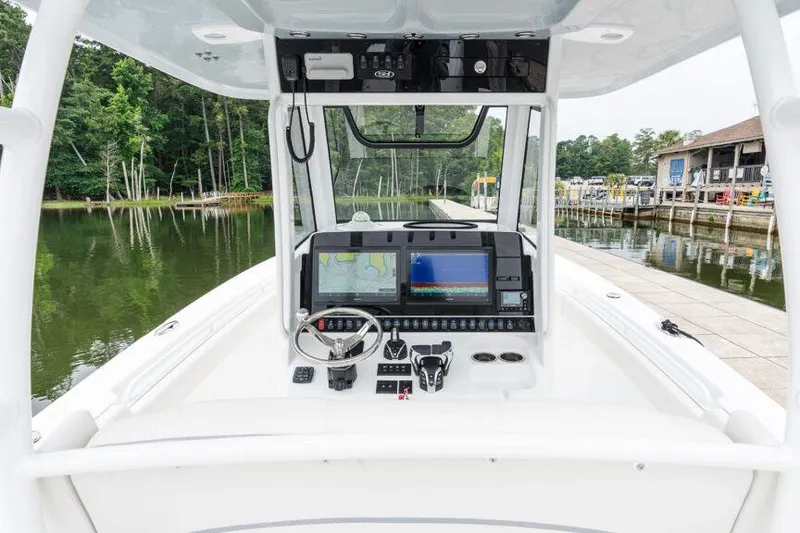 Slide: The Image of Manufacturer Provided Image: 2025 Sea Hunt Gamefish 30 boat dashboard with advanced navigation systems, docked by a serene lake. - 8