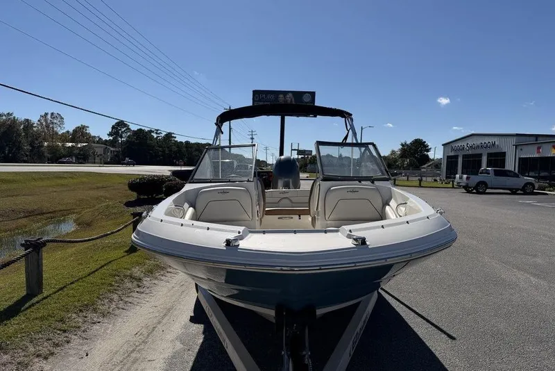 Slide: The Image of 2024 Stingray 191 DC boat interior with cushioned seating and motor view. - 13
