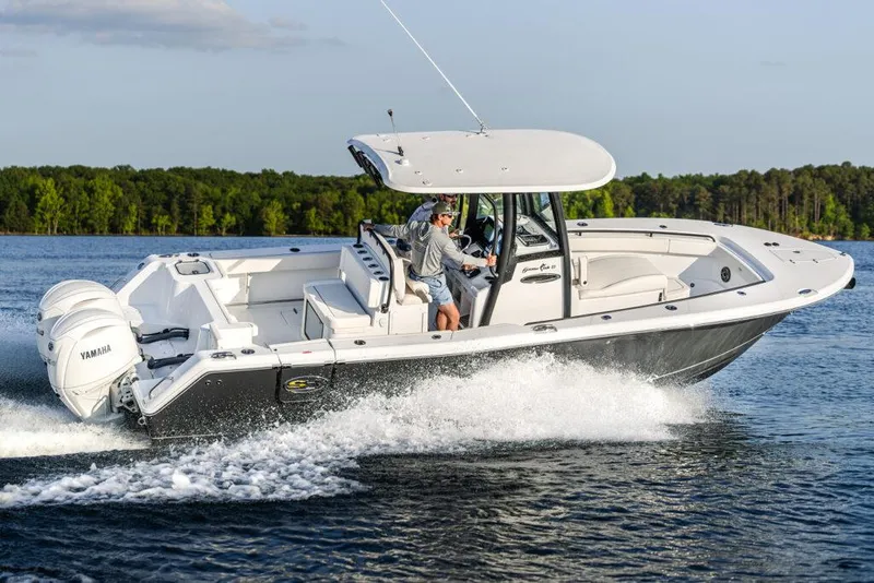 Slide: The Image of Manufacturer Provided Image: 2026 Sea Hunt Gamefish 27 Coffin Box boat cruising on a lake with dual Yamaha engines. - 0