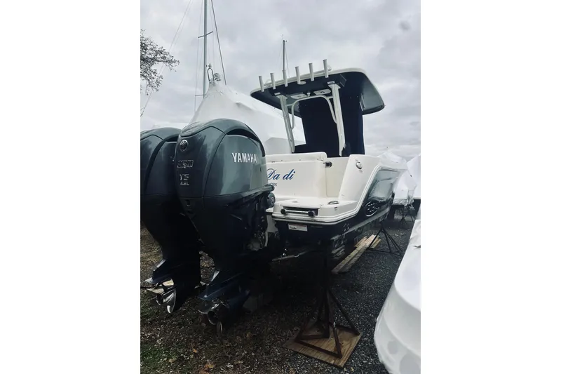 Slide: The Image of 2022 Robalo R272 Center Console boat with Yamaha engines, parked on stands. - 13