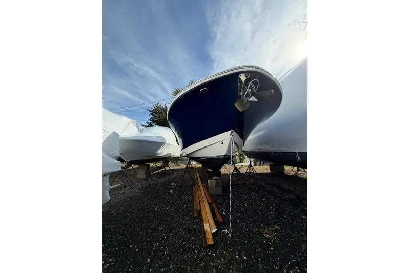 Slide: The Image of 2022 Robalo R272 Center Console boat on stands, under a clear blue sky. - 2
