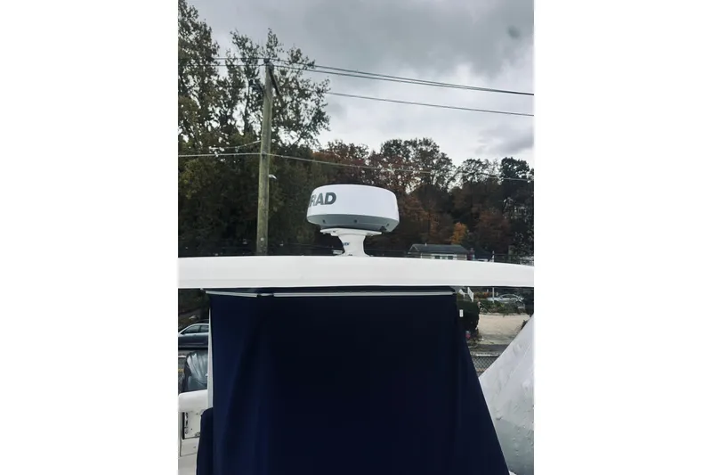 Slide: The Image of 2022 Robalo R272 Center Console boat with radar, under cloudy sky. - 26