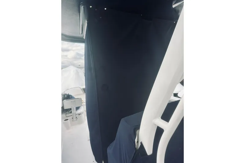 Slide: The Image of 2022 Robalo R272 Center Console interior with dark curtain and white structural elements. - 29