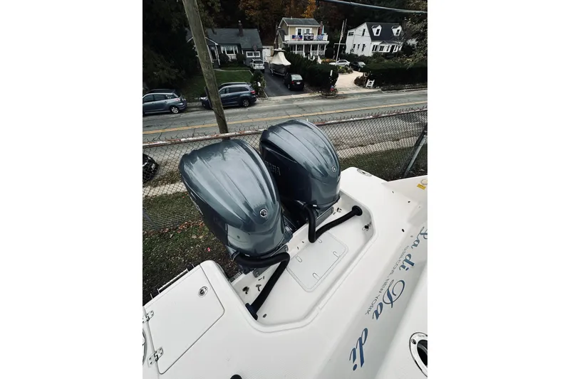 Slide: The Image of 2022 Robalo R272 Center Console with dual outboard motors, parked near residential area. - 37