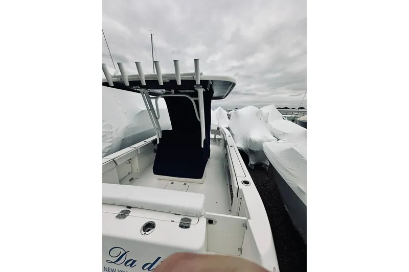 Slide: The Image of 2022 Robalo R272 Center Console boat with covered seating, docked under cloudy skies. - 41
