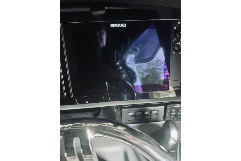 Slide: The Image of 2022 Robalo R272 Center Console dashboard with Simrad display and controls. - 51