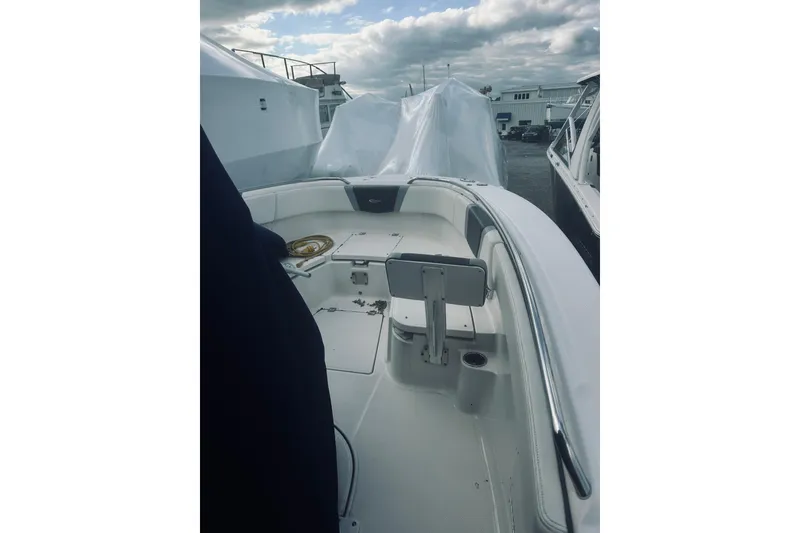 Slide: The Image of 2022 Robalo R272 Center Console boat interior with seating and storage, under cloudy sky. - 54