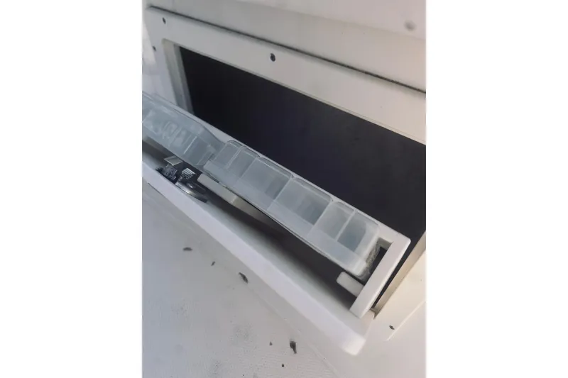 Slide: The Image of 2022 Robalo R272 Center Console storage compartment with tackle box. - 58