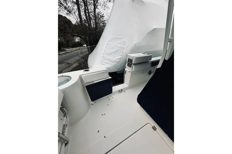 Slide: The Image of 2022 Robalo R272 Center Console boat interior with seating and storage, covered outdoors. - 59