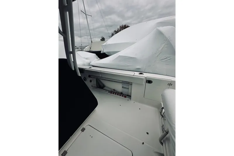 Slide: The Image of 2022 Robalo R272 Center Console boat interior, covered and docked under cloudy skies. - 61