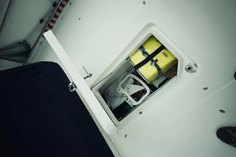 Slide: The Image of Storage compartment on 2022 Robalo R272 Center Console boat, containing safety equipment. - 64
