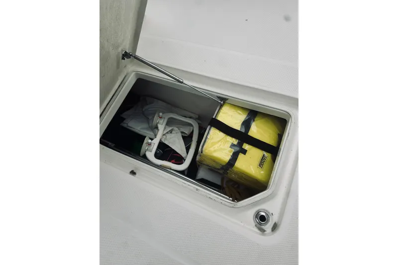Slide: The Image of 2022 Robalo R272 Center Console storage compartment with life jackets and equipment. - 65