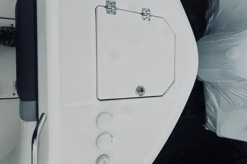 Slide: The Image of 2022 Robalo R272 Center Console boat deck with storage hatch and controls. - 80