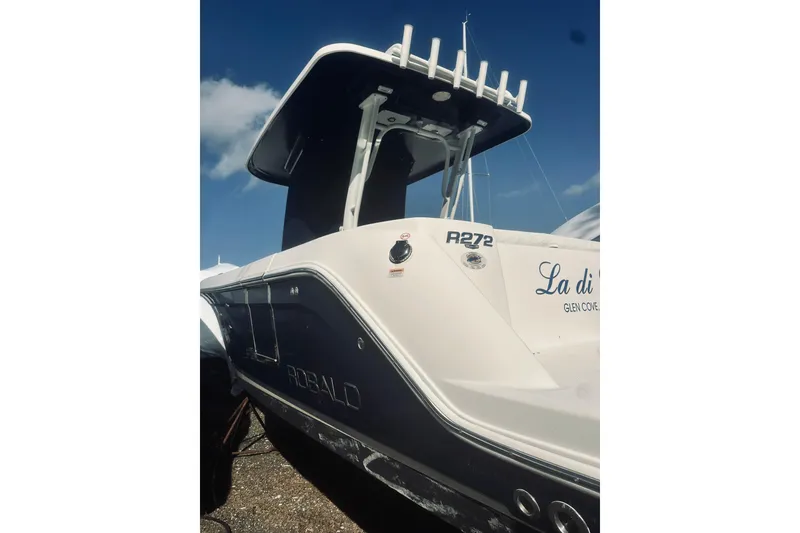 Slide: The Image of 2022 Robalo R272 Center Console boat with sleek design under blue sky. - 9