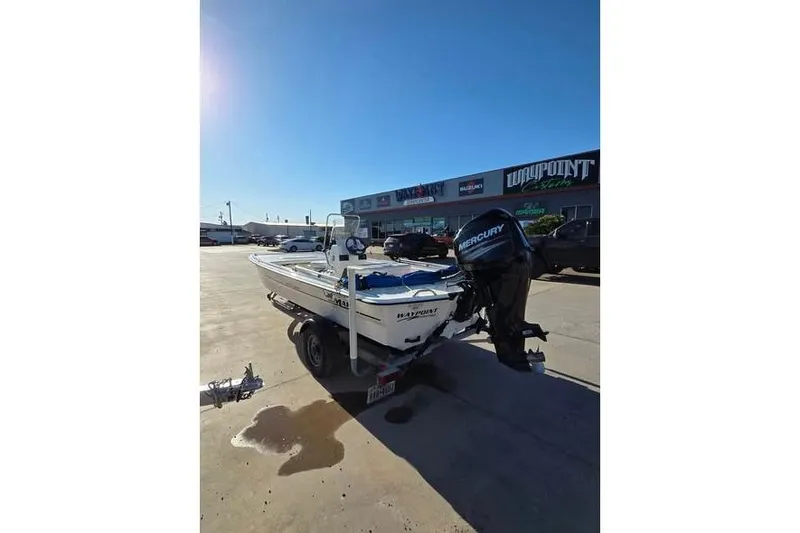 Slide: The Image of 2018 Mako Pro Skiff 17 CC boat on trailer, parked outside dealership under clear blue sky. - 3