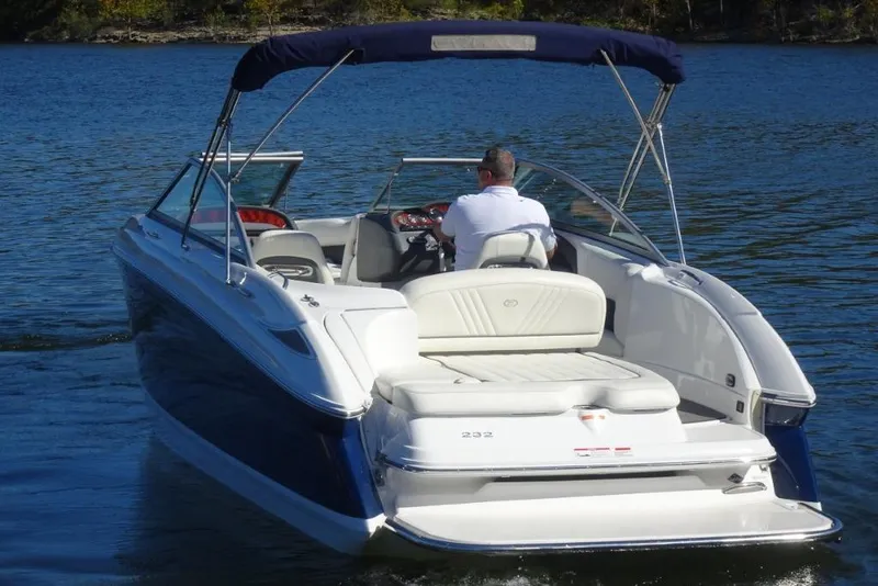 Slide: The Image of 2008 Cobalt 232 boat cruising on a serene lake with a person at the helm. - 4