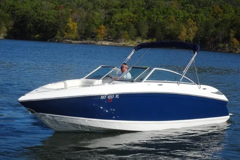 Slide: The Image of 2008 Cobalt 232 boat cruising on a lake with forested shoreline. - 6