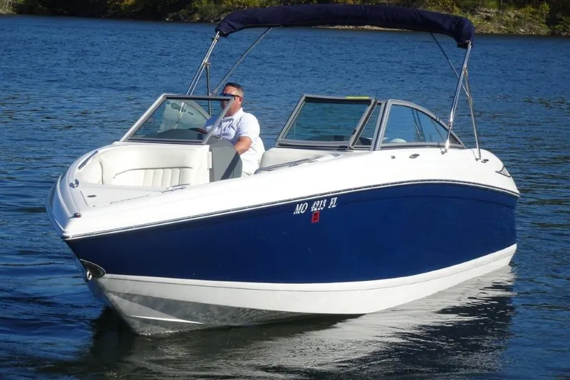 Slide: The Image of 2008 Cobalt 232 boat cruising on a lake with a person at the helm. - 7