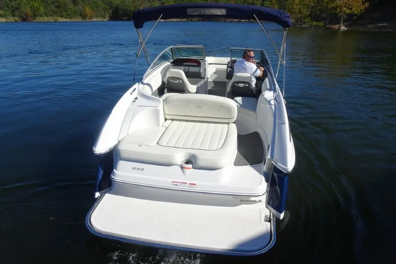 Slide: The Image of 2008 Cobalt 232 boat cruising on a serene lake with a canopy and seating area. - 9