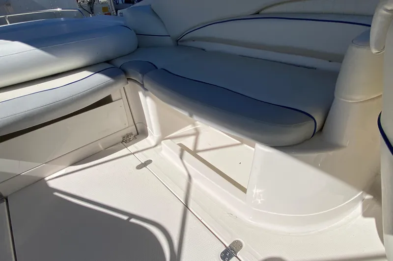 Slide: The Image of Interior seating of a 2002 Monterey 268SS Super Sport boat, featuring white and blue upholstery. - 13