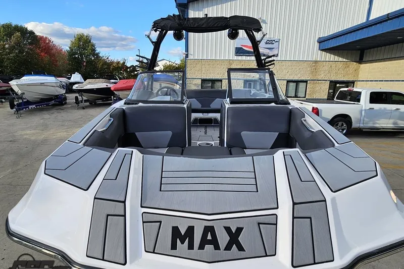 Slide: The Image of 2020 Moomba Max boat with sleek design, parked outdoors near other boats and vehicles. - 16