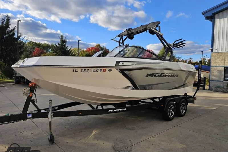 Slide: The Image of 2020 Moomba Max boat on trailer, parked outdoors under a partly cloudy sky. - 21