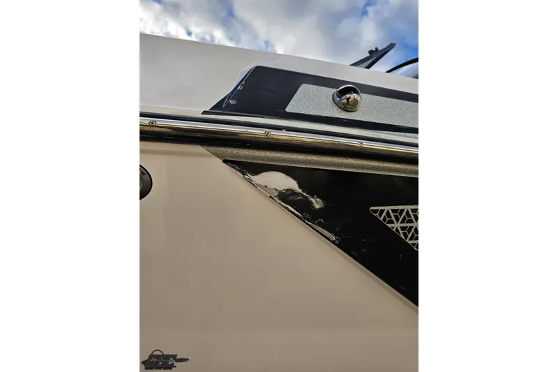Slide: The Image of 2020 Moomba Max boat detail with chrome accents and geometric design under cloudy sky. - 28