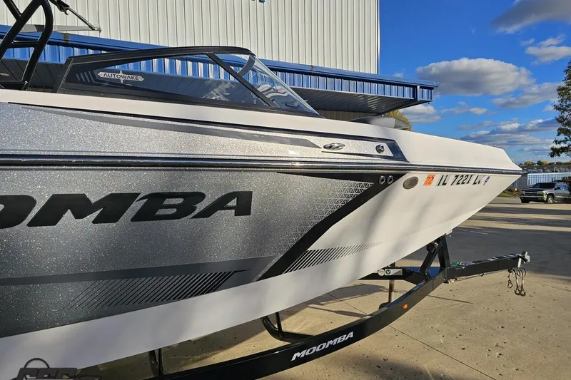 Slide: The Image of 2020 Moomba Max boat on trailer, silver and white design, parked outdoors. - 5