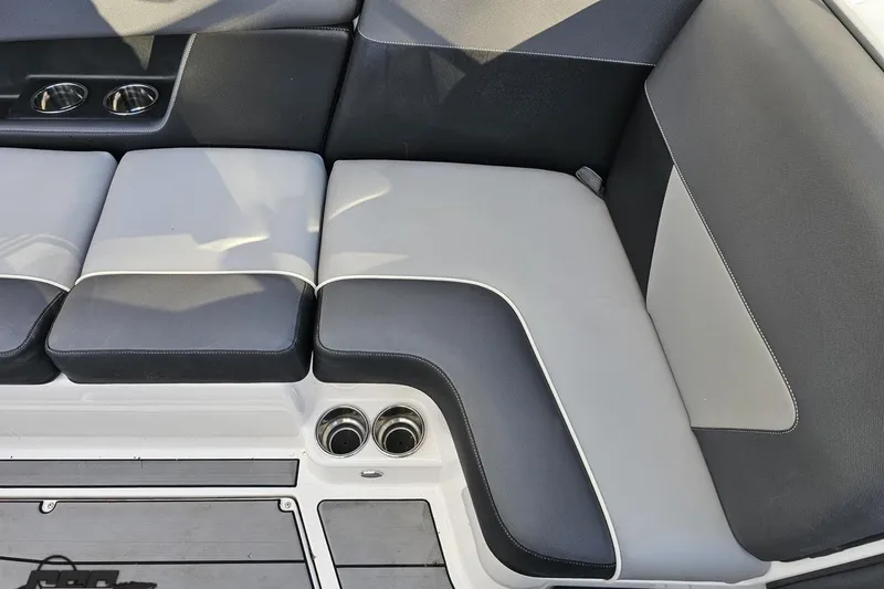 Slide: The Image of 2020 Moomba Max boat interior with gray and black seating, cup holders, and deck flooring. - 54