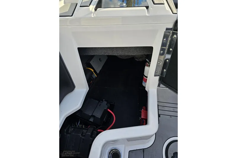 Slide: The Image of 2020 Moomba Max boat interior storage compartment with battery and fire extinguisher. - 67